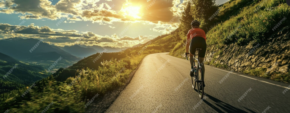 Una vista panorámica que muestre un ciclista pedaleando por una carretera serpenteante en Canarias, con un paisaje espectacular al fondo.